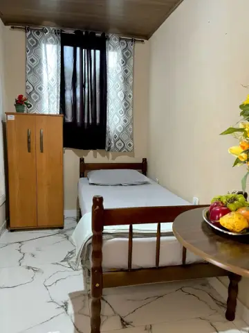 Quarto individual com cama, armário próprio e janela ampla