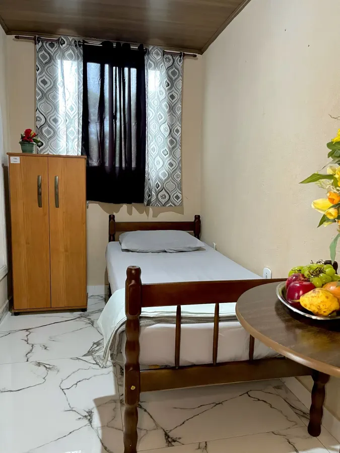Quarto individual com cama, armário próprio e janela ampla